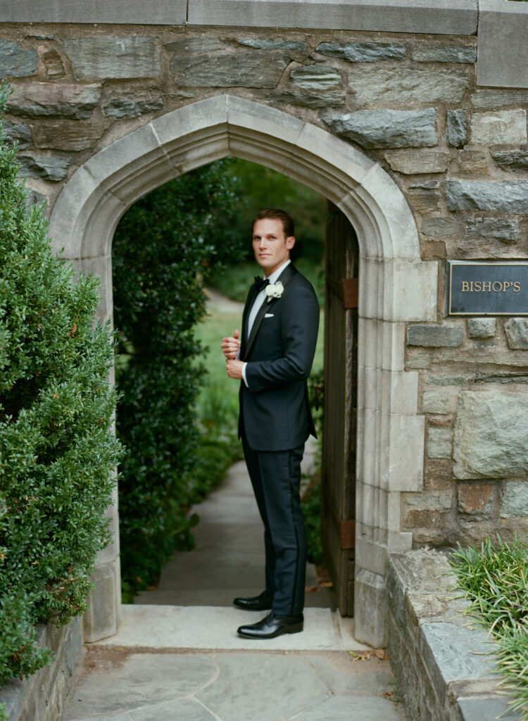 groom-standing-under-door-artch-getting-ready