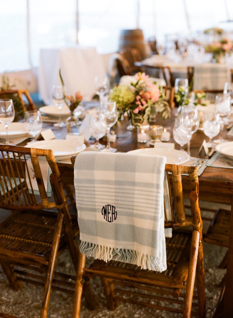 monogrammed-blankets-on-log-cabin-style-wooden-chairs-at-a-tented-wedding
