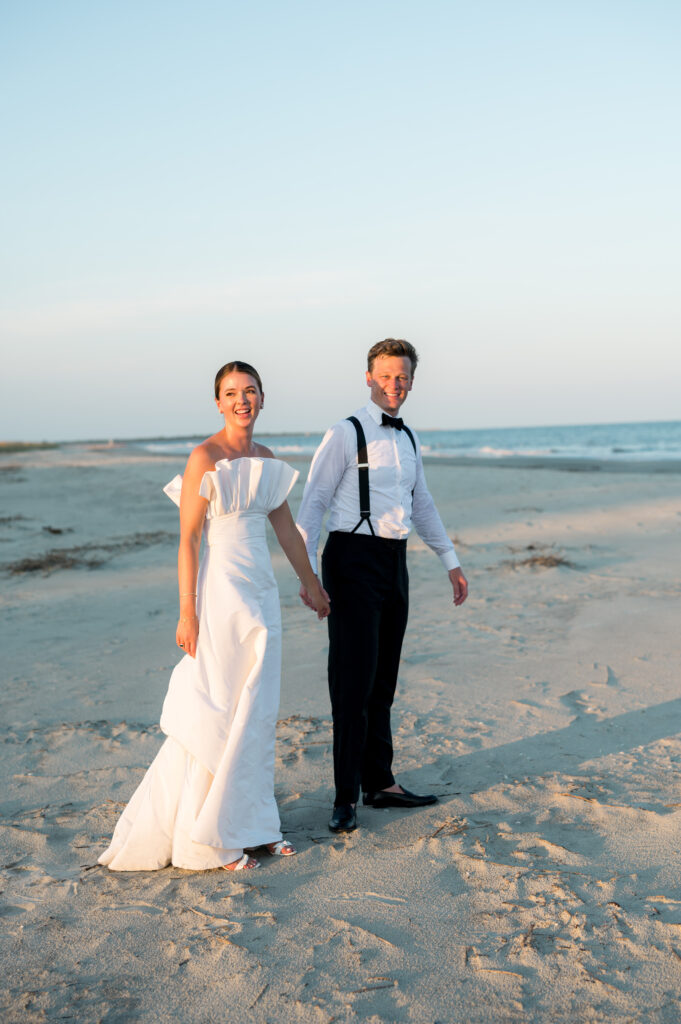 couple-walking-by-the-ocean-on-wedding-day