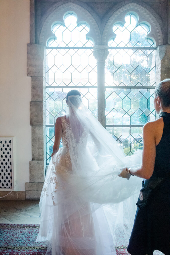 bride-standing-in-front-of-stained-glass-window
