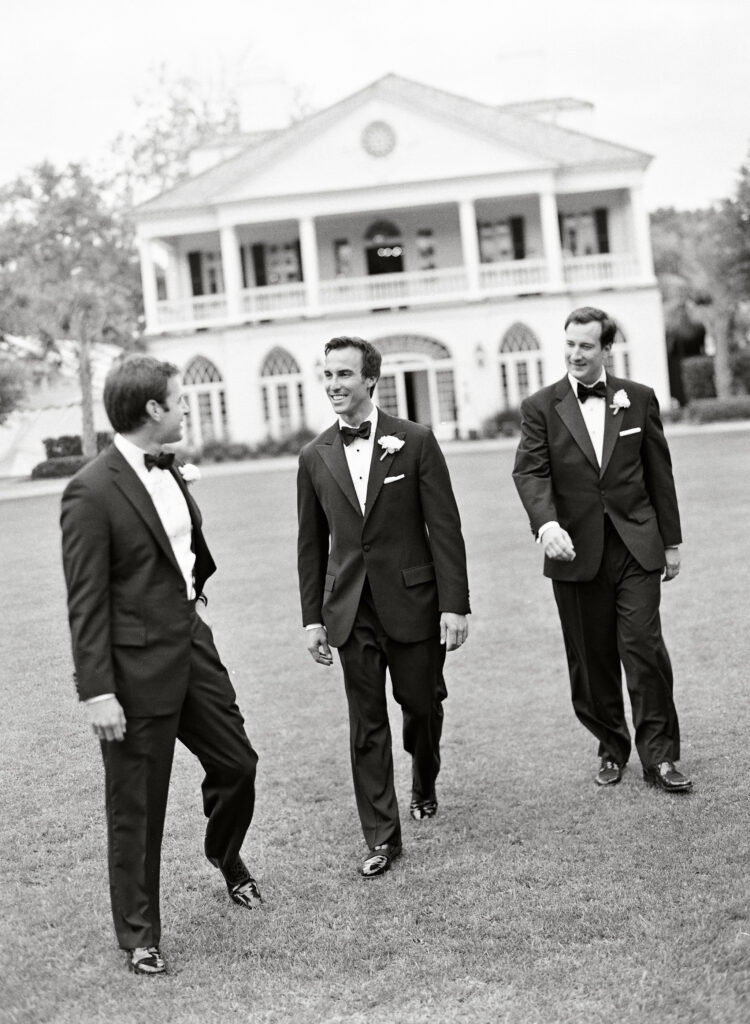 groom-and-groomsmen-walking-in-front-of-historic-home-wedding-venue