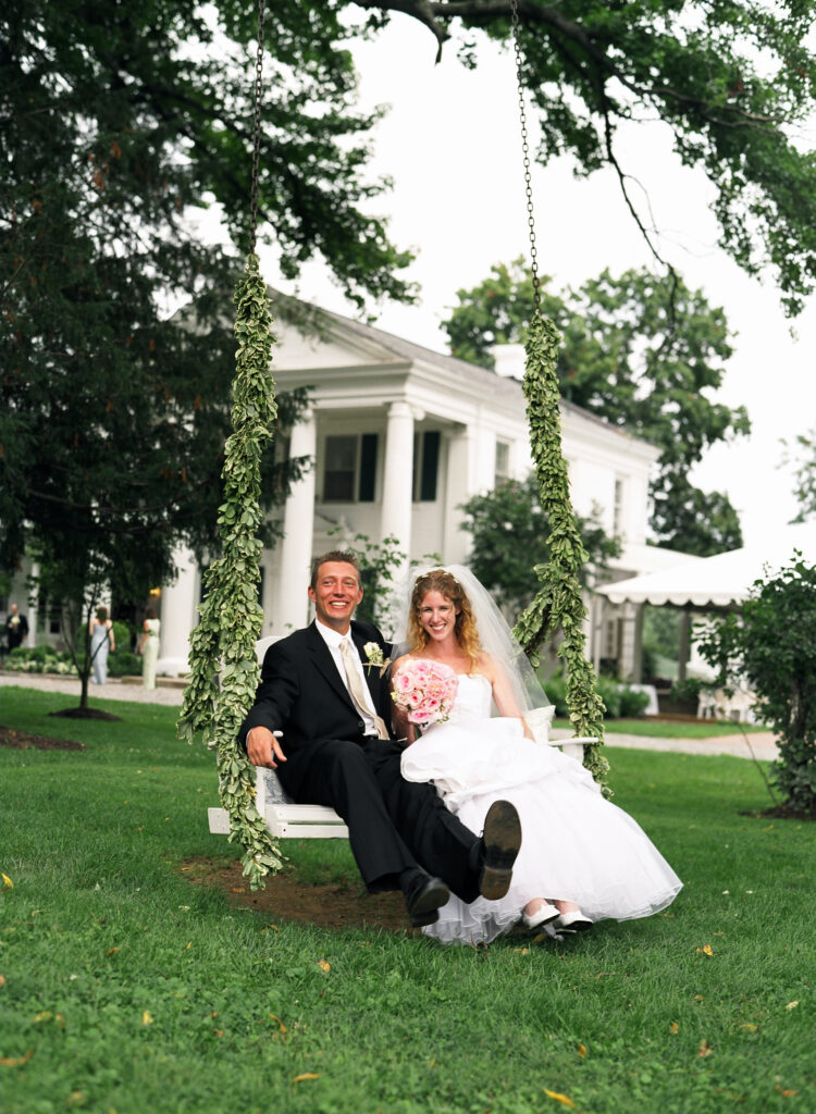 bride-and-groom-on-white-swing-with-green-vines